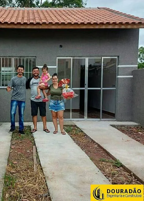 Família recebendo a casa nova construída pela Douradão